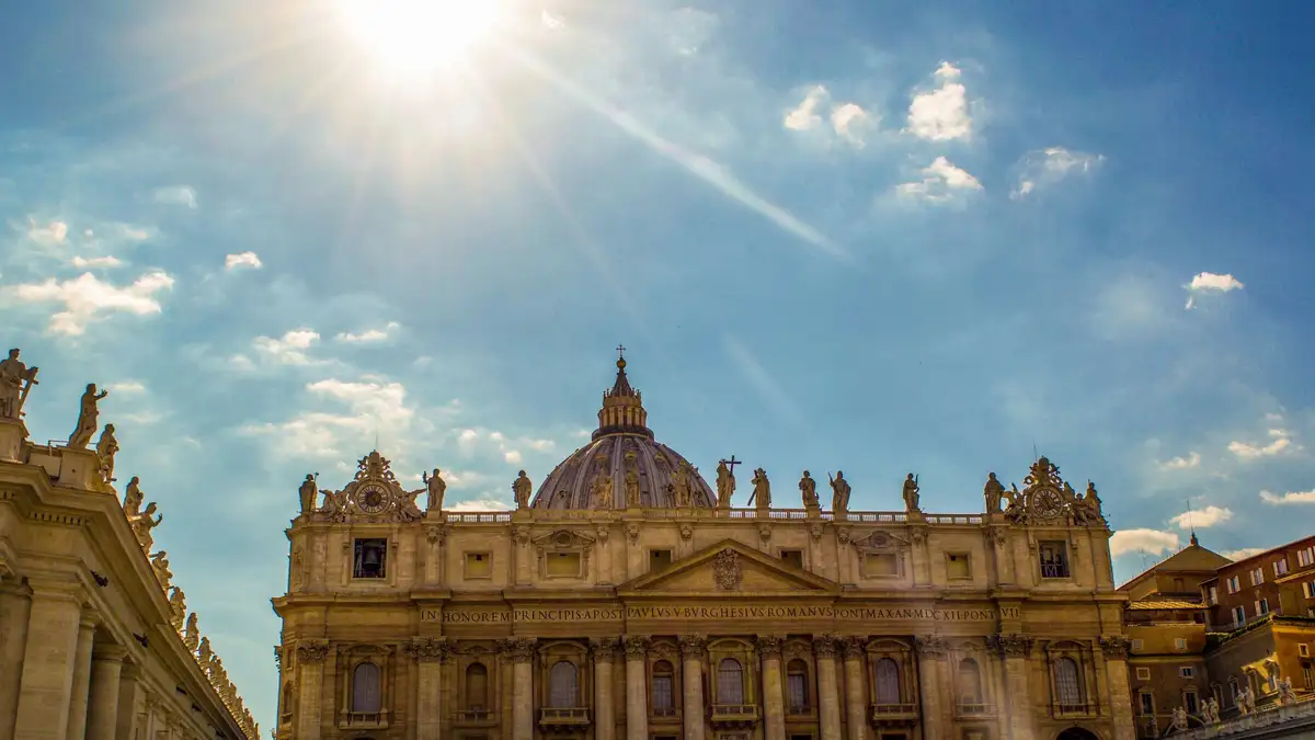 Majestic St. Peter鈥檚 Basilica in Vatican City with grand dome and facade glowing warmly under bright sunlit sky, Catholic pilgrimage icon.
