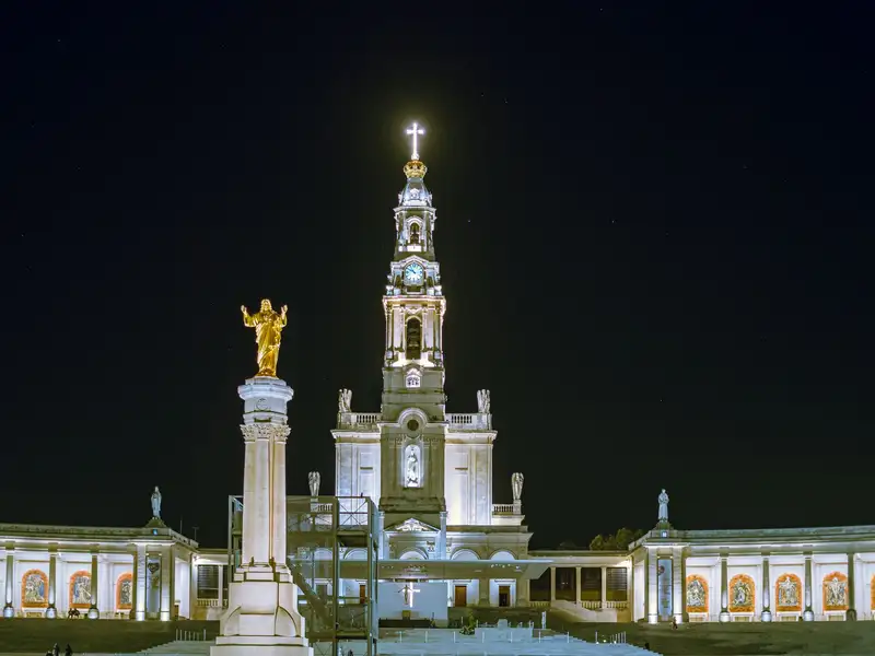 Illuminated Basilica of Our Lady of Fátima at night in Portugal.