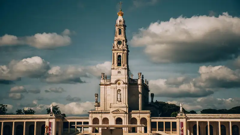 Majestic view of the Sanctuary of Our Lady of Fátima with cumulus clouds in the backdrop.